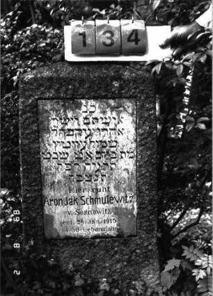 Grabstein 134 (Index: 100101422) Material: Granit, weiße Marmorplatte Zustand: leicht verwittert Maße HxBxT: 94x45x19 cm Beschreibung: obeliskartige Stele, rechteckige Schriftplatte: Grabstein 134