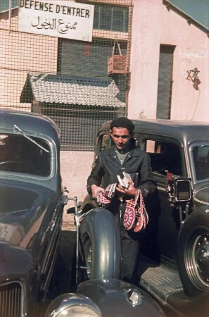 Straßenhändler : Reisefotos. Straßenhändler mit Taschen zwischen parkenden Autos (im arabischen Raum)