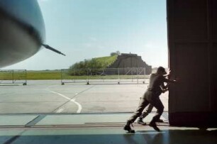 Blick durchs geöffnete Hangartor auf den Flughafen Peenemünde