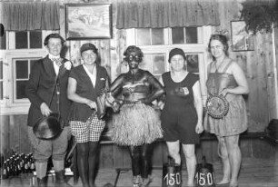 Gruppenbildnis von Mitarbeitern der Landesbildstelle (?) als Sportler verkleidet, aufgenommen wohl nach einem Kulturbeitrag in einer Gaststätte