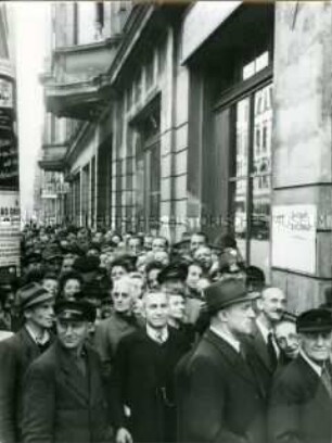 Ost-Berliner warten vor einer Reichsmark-Umtauschstelle