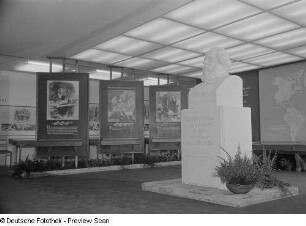 Eine Büste Karl-Marx umgeben von Propaganda Tafeln auf der Technischen Messe 1953