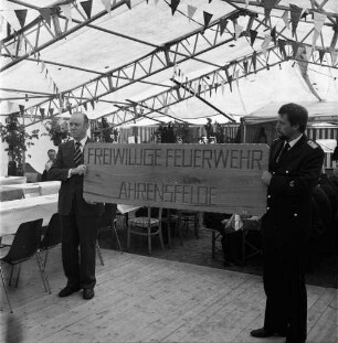 Ahrensfelde: Freiwillige Feuerwehr Ahrensfelde: Festzelt: 50-jähriges Jubiläum: Geschenk der Gemeinde Westerau: zwei Männer mit Holzschild