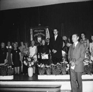 Oldesloer Singakademie von 1946: Oldesloer Hof: Saal: Festveranstaltung zum 25-jährigen Jubiläum: Chor und Chorleiter auf Bühne: hinten Fahne: vorn Blumenschmuck: vorn rechts Vorsitzender des Schleswig-Holsteinischen Sängerbundes Uwe Timmermann: 26.09.1971