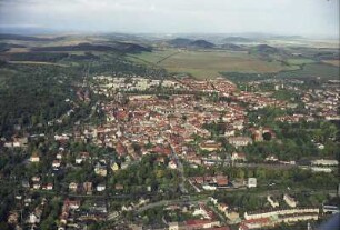 Arnstadt. Stadtzentrum über die Gleisanlagen mit Bahnhof Arnstadt Süd gegen Thüringer Becken mit Drei Gleichen (Mühlburg, Wachsenburg und Burg Gleichen).
