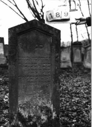 Grabstein 189 (Index: 99752051) Material: Sandstein Zustand: leicht verwittert Maße HxBxT: 125x43x22 cm Beschreibung: Stele, giebelartiger Abschluß, Schriftfeld eingetieft: Grabstein 189