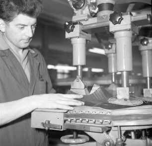 Roßwein. VEB Terra-Schuhfabrik. Schuhproduktion. Technische Neuerungen. Arbeiter an einer Maschine zum Formen der fertigen Schuhe (?)