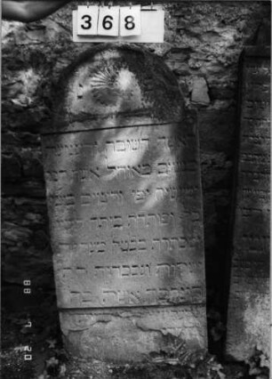 Grabstein 368 (Index: 100094748) Material: Sandstein Zustand: verwitt/unten weggebrochen/Textverlust Maße HxBxT: 135x63x15 cm Beschreibung: Stele, eingezogener Spitzbogenabcshluß Symbolik: Blüte im Abschluß Besonderheit: an Mauer gelehnt: Grabstein 368
