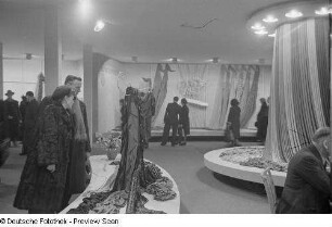 Innenansicht eines Messehauses, Besucher auf der Ausstellungsfläche für Stoffe