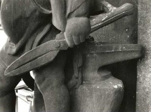 Putto mit Zange und Amboß : Putto mit Zange und Amboß. Sandstein (um 1905). Teilansicht. Dresden-Altstadt, Schloßplatz 1, Baustelle Ständehaus (Bauphase Substanzsicherung / Wiederaufbau Dach)