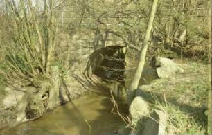 Schäperbarg: Granitquaderbrücke über die Barnitz: Seitenansicht: oben Geländer: vorne an Flussufer Steine