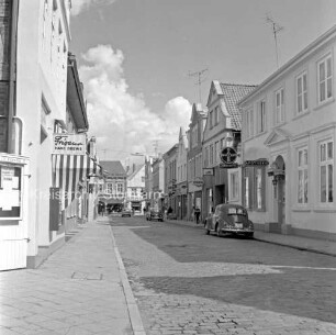 Hindenburgstraße: rechts und links Wohn- und Geschäftshäuser: dazwischen Pkws: hinten Mitte Mühlenstraße mit Kaufhaus Nickel