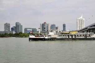 Frachtschiff vor der UNO-Stadt : Ein Frachtschiff nähert sich vor den Hochhäusern der UNO-Stadt dem Donauhafen. Aufgenommen am 2. September 2009 in Wien