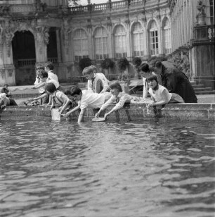 Dresden-Altstadt. Lehrerin (oder Pionierleiterin) mit einer Gruppe Junger Pioniere am Rand eines Brunnenbeckens im Zwingerhof