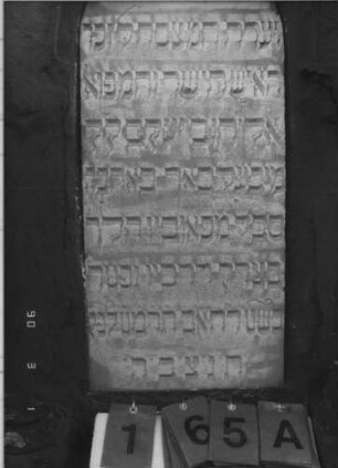 Grabstein 165 (Index: 100114998) Material: Sandstein und ? Zustand: beschädigt, Text sehr gut Maße HxBxT: 230x68x32 cm Beschreibung: Stele auf gestuftem Sockel, Spitzgiebel mit Eckakroteren, Texttafel mit Rundbogen: Grabstein 165A
