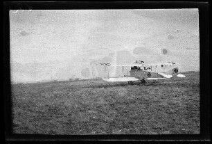 Nicht identifizierbare Ortschaft in Nordfrankreich oder Belgien: Doppeldecker mit Tatzenkreuz auf dem Tragflächen auf einem Feld (Rückansicht)