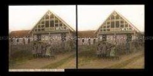 Kindergruppe an einem neu aufgebauten Haus, Uderwangen