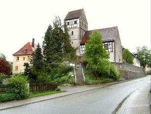 Ansicht von Norden mit Kirche (im Kern Gotischer Neubau auf Vorgänger) in erhöht liegendem Kirchhof über Kirchhofmauer (Wehrgang mit Steinbrüstung im 18 Jh abgetragen)
