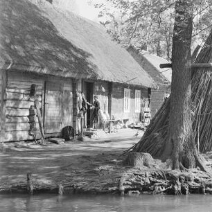 Strohgedecktes Blockhaus in Lehde mit Anlegerstelle. : Ze słomu kryta kładźita chěža w Lědach z přistawnišćom.