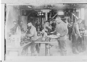 Soldaten der Technischen Betriebe der 27. Infanteriedivision in einer Motorenreparaturwerkstätte