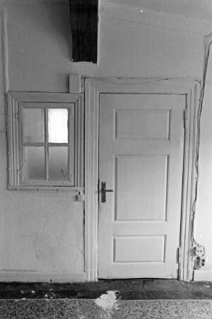 Sprenge: Dorfstraße 16: traufständiges Bauernhaus: Wohntrakt: Innenansicht: Flur: Stubentür, daneben kleines Wandfenster mit Beschlägen: Terrazzoboden