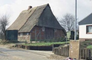 Bünningstedt: Steenhoop: Fachwerkkate mit Reetdach: Giebelseite Wirtschaftstrakt mit Scheunentor: traufenständige Straßenfront