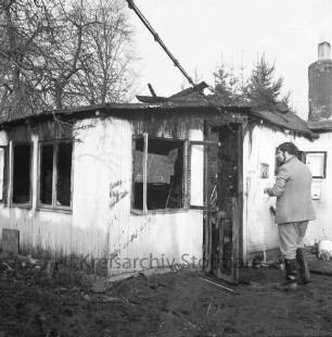 Brand: Sieker Landstraße: Behelfsheim: Brandruine mit eingestürztem Dach: rechts neben Eingang Brandsachverständiger: hinten Bäume