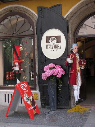 Salzburg, historisches Cafe in der Getreidegasse neben dem Mozart-Geburtshaus mit Standbild Mozart (Werbung für Mozartkugeln)