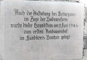Inschrift in Niederkaina : Dorfsiedlungen. Ort: Delnja Kina / Niederkaina. Das erste Neubauerngehöft im Bautzener Landkreis, Haus Nr. 21 c. Der Stein ist in die Scheunenwand eingemauert.
