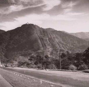 Brasilien, Serra do Mar, Autobahn Santos - Sao Paulo gegen bewaldete Bergkette mit Fallrohren eines Wasserkraftwerks, um 1960