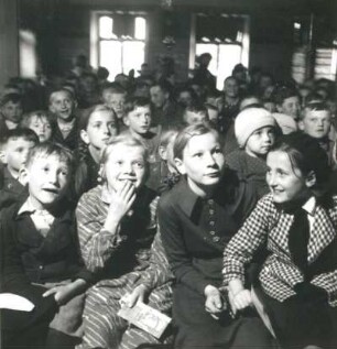 Schulkinder als Publikum des Puppenspielers Carl Schröder