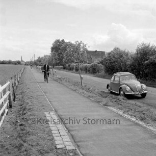 Straßen: Radweg mit Fahrradfahrern am Autobahnzubringer zur A 1: rechts VW-Käfer: Blick auf Siek im Hintergrund