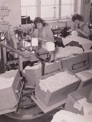 Limbach-Oberfrohna. Fa. Hermann Dittrich. Nähen von Damenperlonwäsche an Spezialmaschinen - im Vordergrund Transportband von und zu den Arbeitsplätzen.