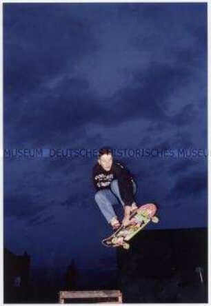 Jugendlicher beim Sprung auf dem Skateboard (Altersgruppe 18-21)