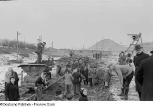 Angestellte der Stadtverwaltung beim Entladen eines Kipplorenzugs