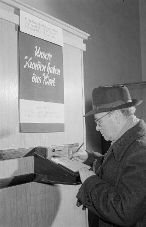 Kunde in einem Warenhaus der Handelsorganisation (HO), an der Wand der Hinweis " Unsere Kunden haben das Wort"