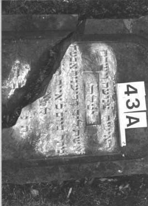 Grabstein 43 (Index: 100105904) Material: Sandstein Zustand: Stein liegend, quer gebrochen mit Textverlust Maße HxBxT: 133x60x17 cm Beschreibung: rechteckige Stele, Sockel, Schriftfeld eingetieft mit Spitzbogenabschluß Symbolik: Maßwerk: Grabstein 43A (3)