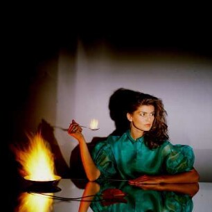 Model in Kleid mit Feuer in einer Schale