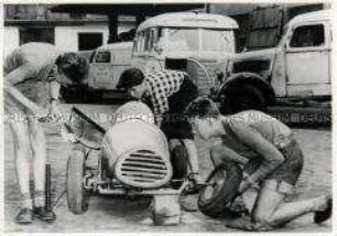 Jungen bei der Reparatur eines Rennwagens
