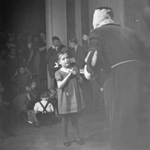 Ein Mädchen steht vor dem Weihnachtsmann, Kinderfest zur Weihnachtszeit