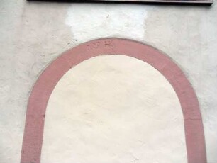 Langhaus (im Kern Romanisch) im Nordosten-vermauerte Tür mit 15 und Initialen TK im Schlußstein (Überarbeitung und Umbau)