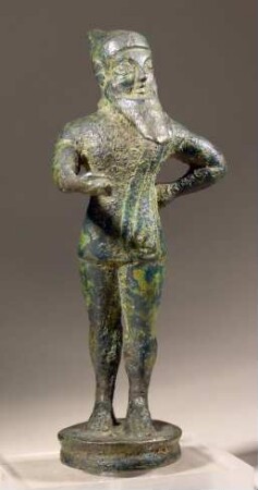 Etruskische Kandelaberbekrönung. Statuette eines langbärtigen Mannes mit spitzer Mütze. Spaßmacher (?)