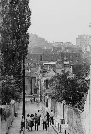 Straße an einem Hang mit Blick über den Ort