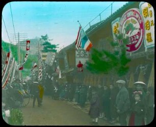 Nagasaki, Japan. Blick in eine belebte Geschäftsstraße mit Einheimischen und Touristen in Rikschas