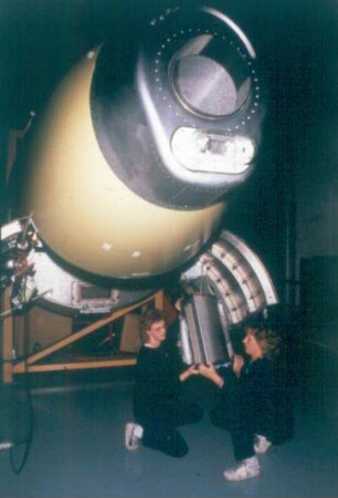 Weibliche Azubis beim Ansetzen eines Bugteiles an eine Airbus-Maschine in einer Montagehalle