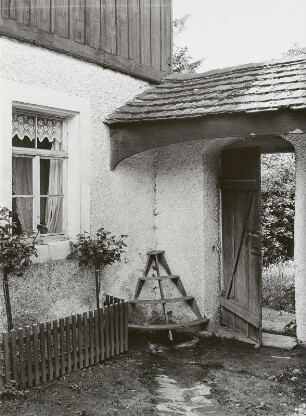 Erdgeschoßfenster des Wohnhauses und Mauer mit Pforte zum parkähnlichen Garten