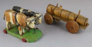Zwei hölzerne Ochsen mit einem Düngewagen