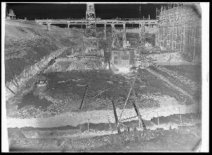 Staustufe Limbach. Krafthausbaugrube von oberstrom gesehen. Felsaushub für Herdmauer und Saugschlauchgründung. Dahinter Transportbrücke, rechts Krafthaustrennpfeiler.