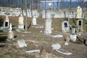 Friedhof mit alten Grabsteinen, im Hintergrund Friedhofsmauer
