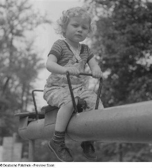Kind auf einer Wippe auf einem Spielplatz im im Clara-Zetkin-Park